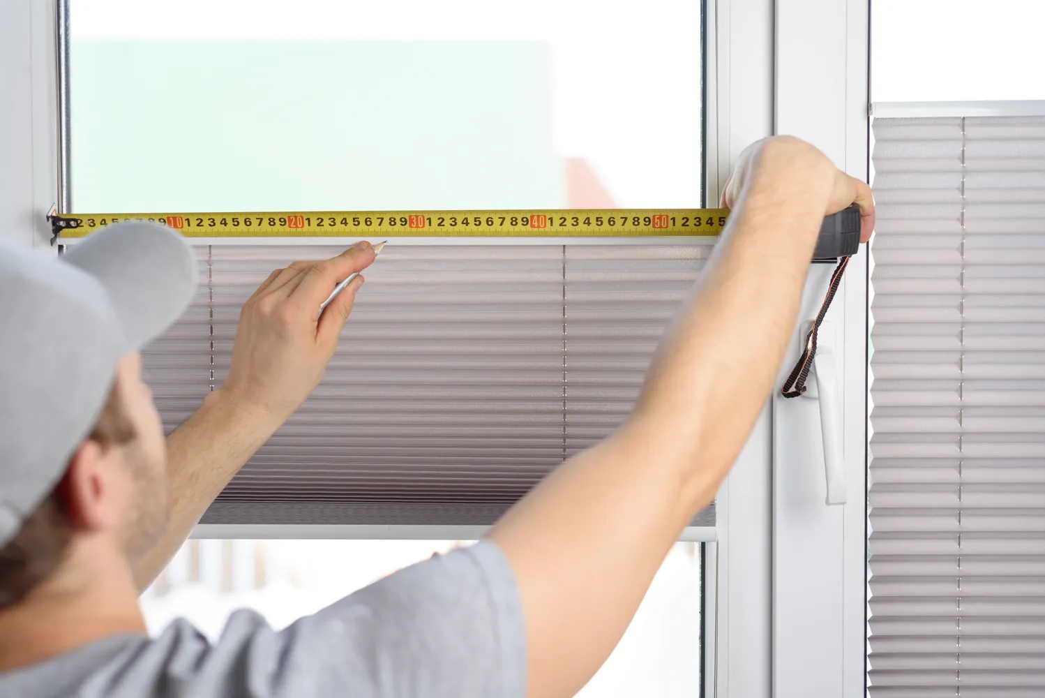 Window treatment installer measuring blinds at a pre-qualified appointment booked through Driive